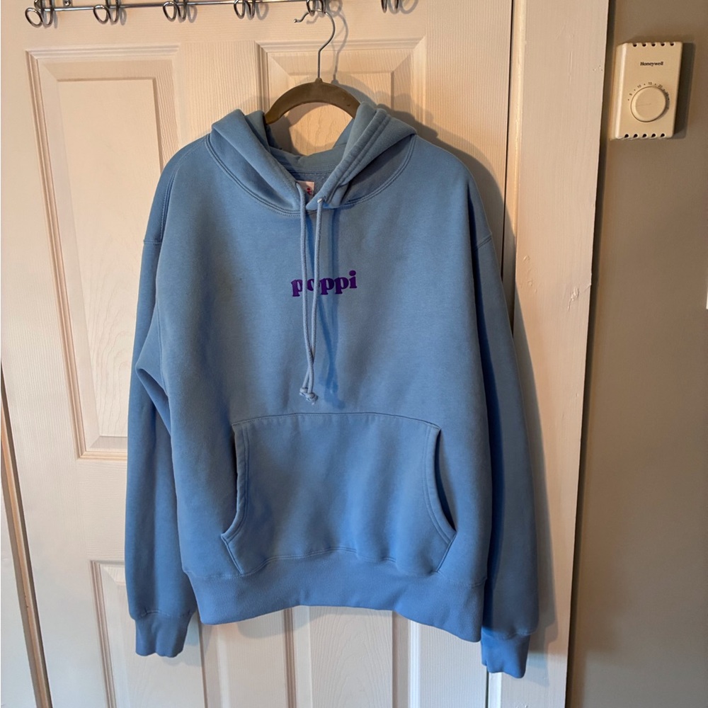 pop soft blue hoodie with red poppi tag